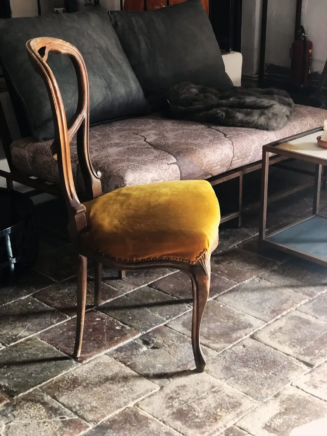 Vintage chair in front of new rustic metal furniture at Finca Legado